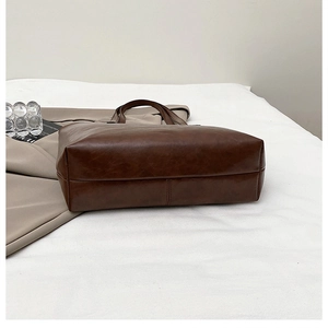 Detail view of the wide reinforced bottom on a dark brown vintage oversized tote bag
