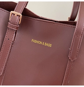 Détail du sac cabas bordeaux avec boucle dorée et lettrage doré élégant