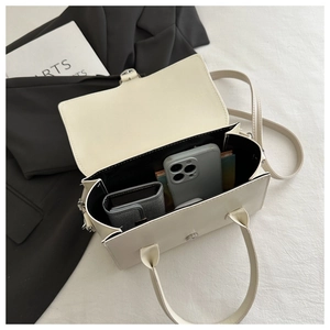 Interior view of off-white crossbody bag showing magnetic flap and storage space
