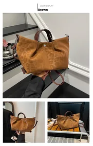 Detail view of brown leopard print embossed tote with dual handles and crossbody strap