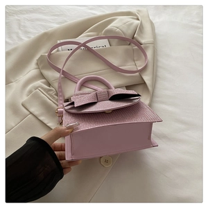 Detailansicht der rosa Pailletten-Handtasche mit glitzernder Schleife und elegantem Griff