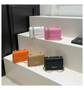 Detail of five colorful mini square chain bags with vertical texture and gold lettering