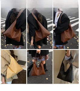 Close-up of three woven leather hobo bags in caramel brown, creamy yellow, and classic black