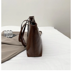 Side view of brown retro tote bag showing premium stitching and structured leather profile