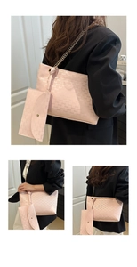 Detail view of pink quilted tote bag with metal chain strap and small detachable pouch