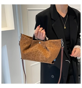 Detail of leopard print tote bag featuring silver magnetic clasp and pleated faux suede