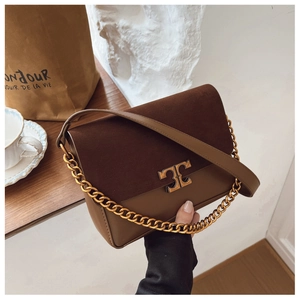 Detailed shot of brown flap shoulder bag with gold T-shaped clasp and chain strap