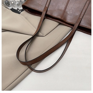 Detailed view of deep brown vintage tote bag with vertical stitching and smooth leather texture