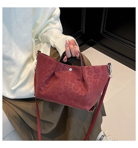 Detail of burgundy leopard texture tote bag with silver hardware and adjustable strap