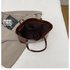Top view of large dark brown tote bag showing spacious interior and zippered inner pocket