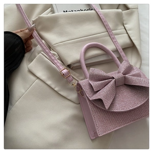 Details der rosa Mini-Tasche mit Strasssteinen, großer Schleife und goldener Hardware