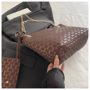 Detail shot of brown monogram tote bag with gold chain straps and matching coin purse