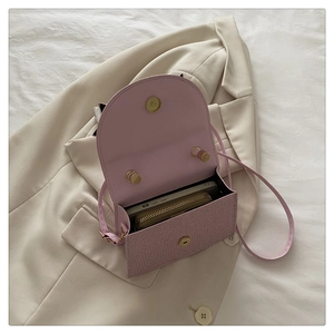 Détail de l'intérieur d'un sac bandoulière rose avec espace pour téléphone et portefeuille