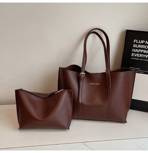 Détail du grand sac cabas en cuir marron avec lettrage doré et sa pochette assortie