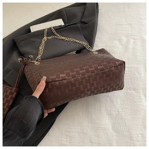 Close-up of brown faux leather chain bag featuring repeated letter print and mini pouch