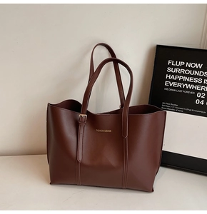 Détail du grand cabas en cuir mat marron foncé avec boucle dorée et texte imprimé