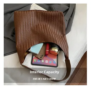 Macro detail of brown woven hobo bag interior showing its large storage capacity