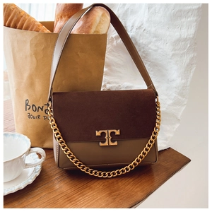 Close-up of dual-tone leather shoulder bag with suede finish and gold chain detail