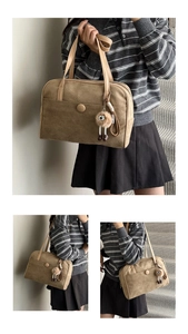 Detail of khaki suede shoulder bag featuring a front pocket with large round buckle and plush toy