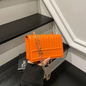 Orange quilted faux leather crossbody bag with gold chain strap for casual daily use