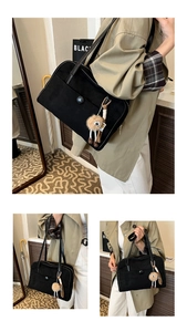 Detail of black frosted shoulder bag with zipper and cute brown plush monster charm pendant