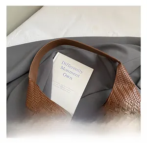 Close-up of brown woven faux leather handbag showing detailed texture and handle design