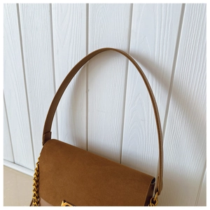 Detail of dark caramel suede and smooth leather bag with gold chain and strap