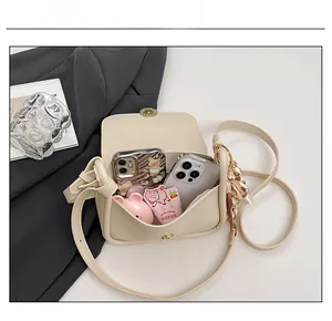 Top view of beige small square bag showing capacity for phones and cosmetics