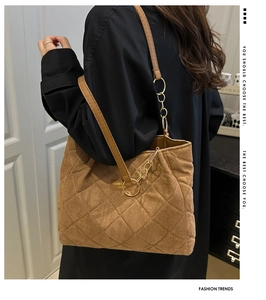 Detail view of brown quilted tote bag showing fine suede texture and gold chain hardware