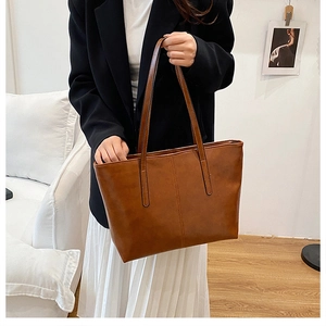 Detail of vintage brown tote bag with vertical stitching and smooth faux leather texture