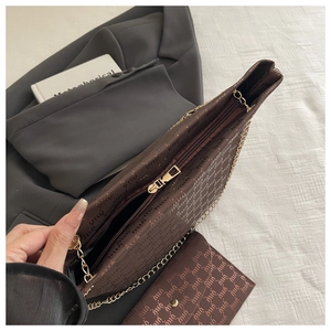 Close-up of brown letter pattern tote bag with gold chain strap and matching wallet