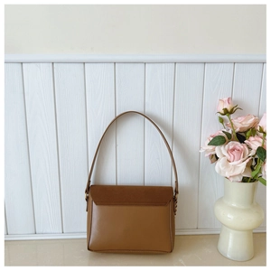 Detail view of the brown leather shoulder bag with suede patchwork and fine stitching