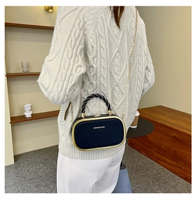 Detail of elegant black crossbody bag with gold metal frame and fashion bag text