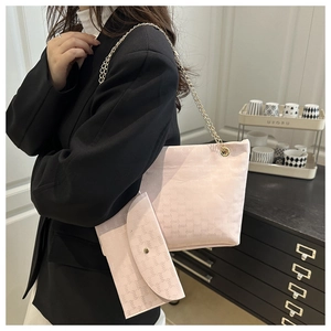 Detail of pink faux leather tote set with embossed letters and golden chain strap