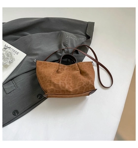 Detail of leopard print tote bag showing suede texture, leather handles and stitch details