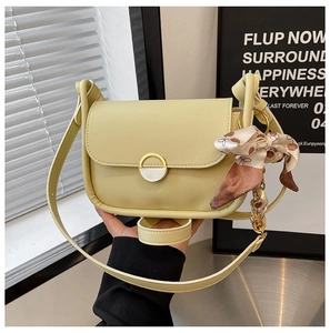 Detail of cream crossbody bag with gold metal buckle and decorative printed silk scarf