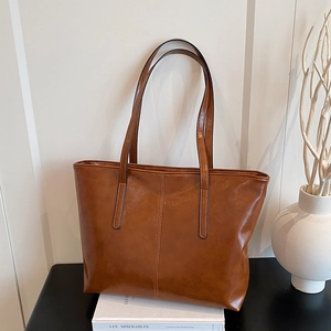 Brown large capacity leather tote bag with vertical stitching on minimalist background