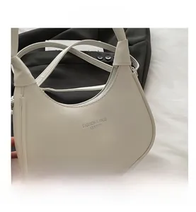Close-up of white crescent shoulder bag with zipper and Fashion & Bags Leather printing