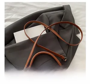 Detail showing adjustable strap buckle and vintage brown leather texture of the crossbody bag