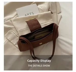 Spacious interior of a brown suede baguette bag showing large storage capacity