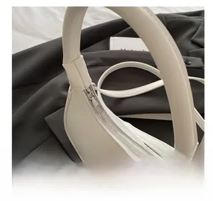 Close-up of smooth silver zipper and premium PU leather on crescent shoulder bag