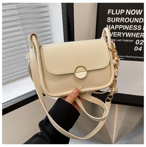 Detail of off-white leather handbag featuring golden round buckle and silk scarf strap