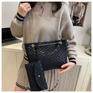Detail of black tote bag with logo embossing and matching long flap wallet with chain