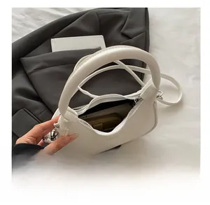 Internal view of a white leather crescent bag showing storage capacity for daily items