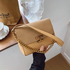 Khaki suede chain shoulder bag with gold T-clasp in a refined lifestyle setting