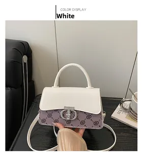 Close-up of white and purple monogrammed crossbody bag with gold metal ring clasp