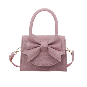 Sac à bandoulière rose pailleté avec grand nœud et détails dorés sur fond blanc