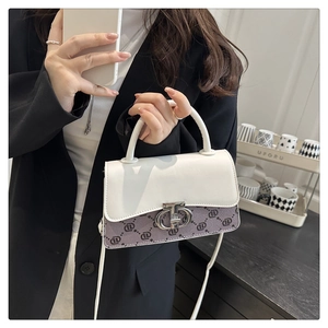 Detail of trendy color-block crossbody bag with metal ring clasp and patterned texture