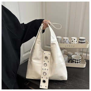 Vue détaillée du sac Hobo blanc crème avec des rivets à œillets sur la large bandoulière