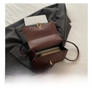 Detail view of large brown leather handbag interior showing spacious capacity and gold lock